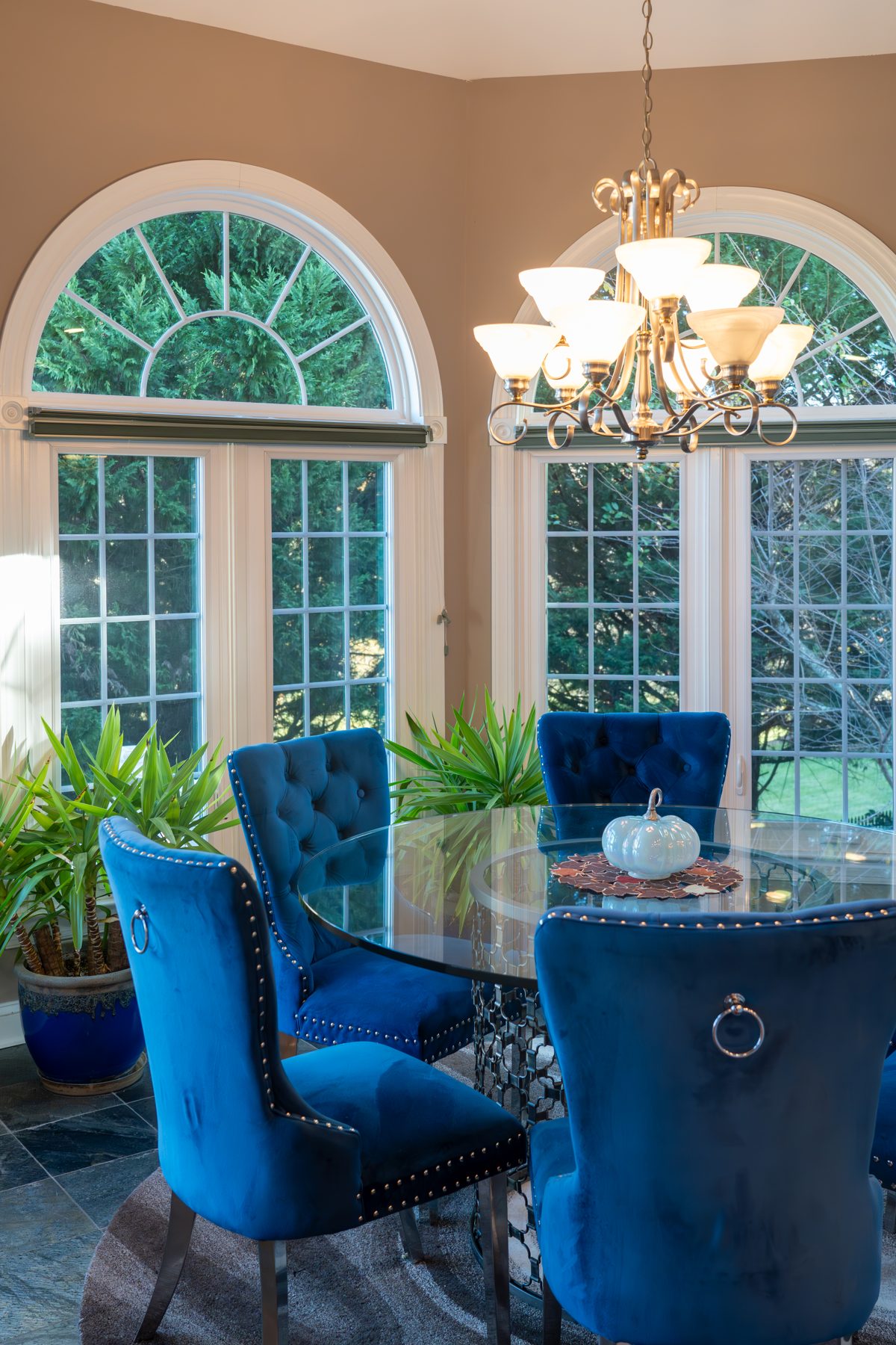 White Vytex Fortis windows with arched half-round transoms and colonial grids in an elegant dining room