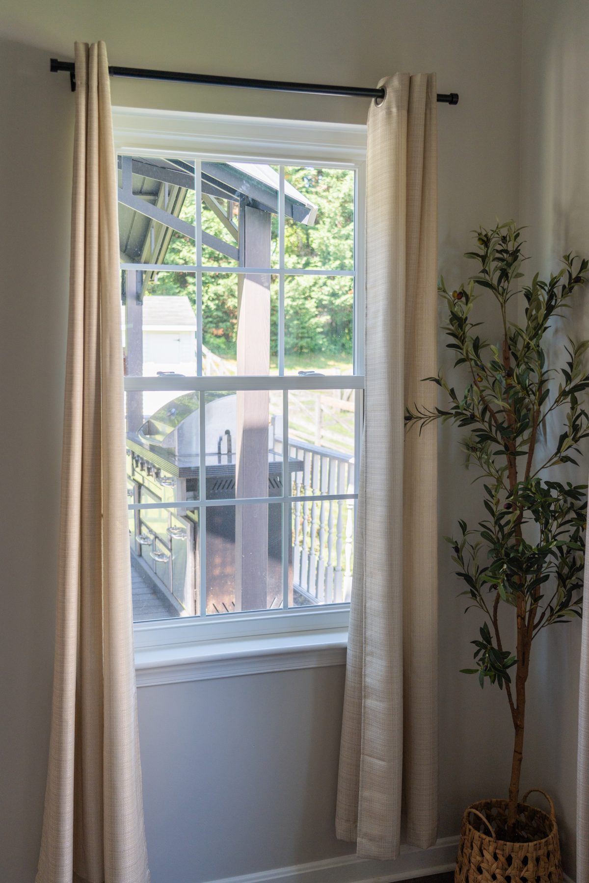 White Vytex Fortis double-hung window with 6-over-6 colonial grids overlooking a backyard deck